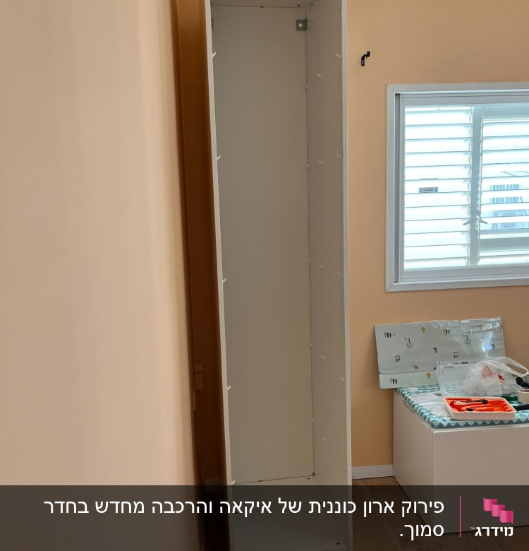 ארון לבן בבנייה עם כלים על הרצפה